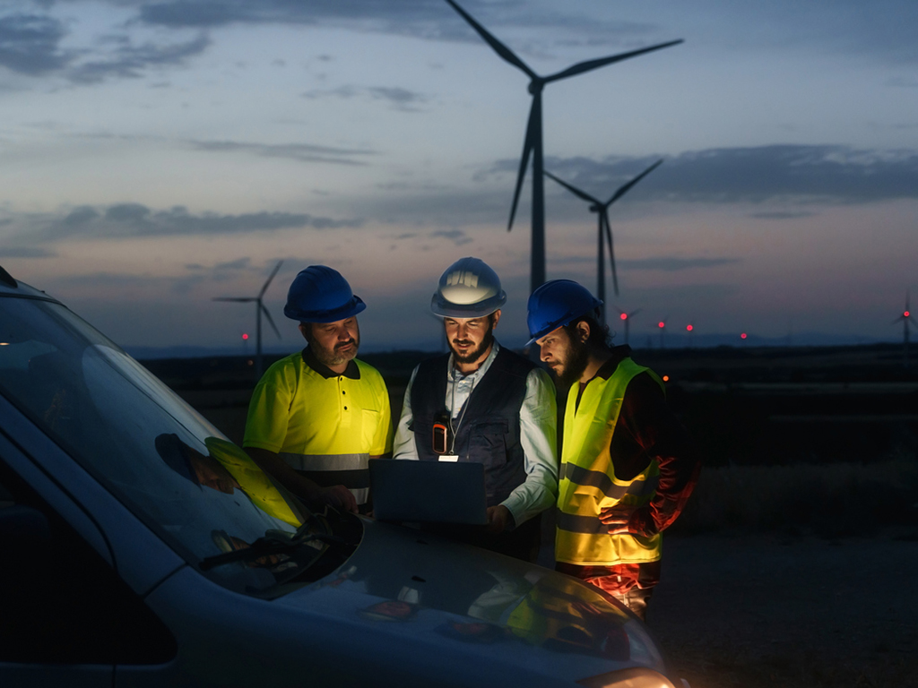 Technicians engineers working in wind turbine electricity plant at night. Renewable energy solution for climate change